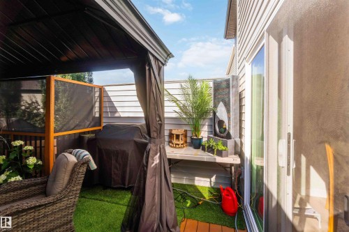 Covered patio featuring a permanent overhead structure, wood-look flooring, and a sliding glass door - 91 Hilton Cove, Spruce Grove, AB -  With Exterior
