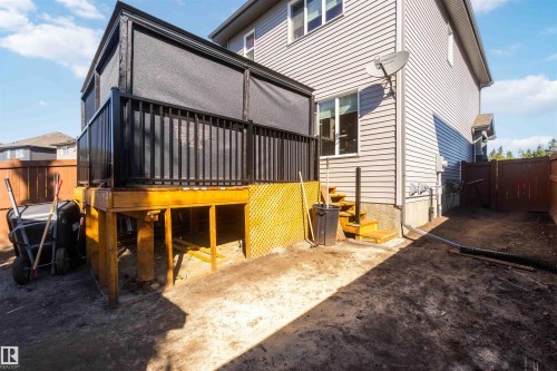 Elevated deck with black metal railing and shade canopy, built over a ground-level storage area featuring yellow metal framework and mesh safety panels - 91 Hilton Cove, Spruce Grove, AB - Outdoor With Deck Patio Veranda