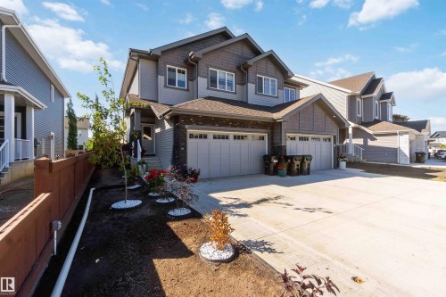 Contemporary exterior featuring horizontal siding, brick accents, and a dual-panel garage door - 91 Hilton Cove, Spruce Grove, AB - Outdoor With Facade