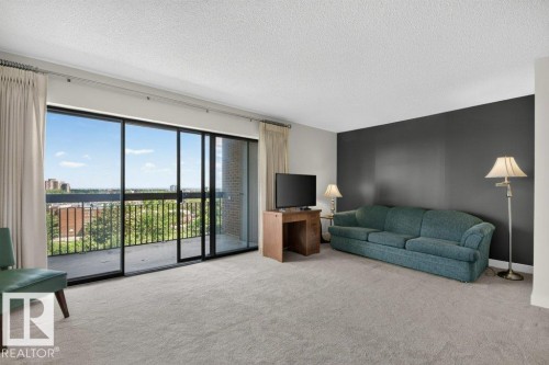 Living area featuring expansive sliding glass doors opening to a private balcony - #804 11027 87 Av Nw, Edmonton, AB - Indoor Photo Showing Other Room