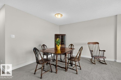 Neutral-toned room featuring a light-colored wall finish, white baseboards, and textured ceiling - #804 11027 87 Av Nw, Edmonton, AB - Indoor Photo Showing Dining Room