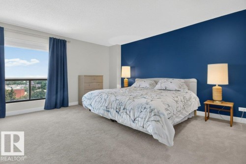 Spacious bedroom featuring neutral carpeting and a bold accent wall - #804 11027 87 Av Nw, Edmonton, AB - Indoor Photo Showing Bedroom