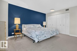 Expansive room featuring a prominent blue accent wall and neutral carpeting - 