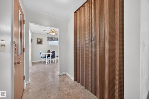 Hallway with wood-finish flooring and a built-in accordion door - 5207 48 Avenue, Leduc, AB - Indoor Photo Showing Other Room