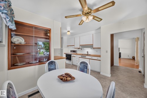 Kitchen featuring white cabinetry, wood-finish countertops, and a built-in display cabinet - 5207 48 Avenue, Leduc, AB - Indoor Photo Showing Dining Room