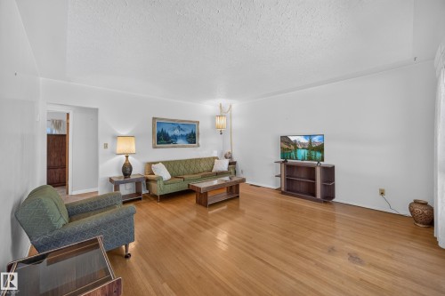 Hardwood flooring throughout, white painted walls, and a textured white ceiling - 5207 48 Avenue, Leduc, AB - Indoor Photo Showing Living Room