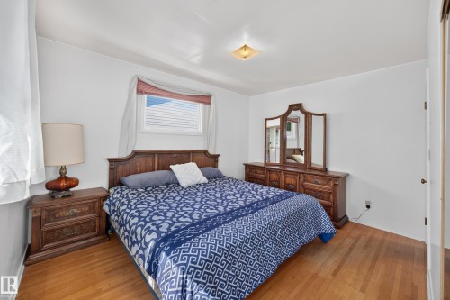 Hardwood flooring, white walls, and a window with blinds - 5207 48 Avenue, Leduc, AB - Indoor Photo Showing Bedroom