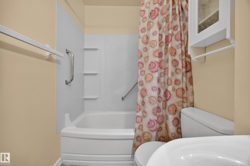 Bathtub with integrated shelving, grab bar, and wall-mounted storage cabinet - 5207 48 Avenue, Leduc, AB - Indoor Photo Showing Bathroom