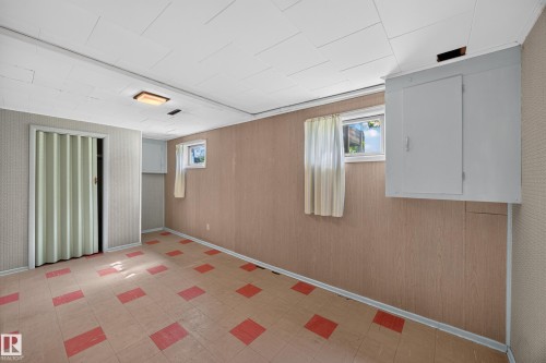 Recessed ceiling light, wall-mounted cabinetry, windows, accordion-style door, patterned flooring - 5207 48 Avenue, Leduc, AB - Indoor Photo Showing Other Room