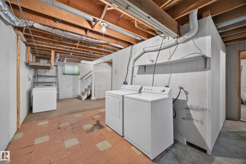 Basement utility area with exposed ceiling joists, concrete walls, and a staircase - 5207 48 Avenue, Leduc, AB - Indoor Photo Showing Laundry Room