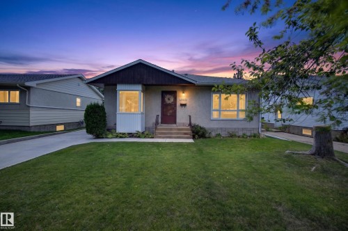 Stucco exterior with a contrasting dark fascia, bay window, and a concrete driveway - 5207 48 Avenue, Leduc, AB - Outdoor With Facade
