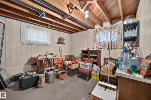 Wood-finish paneled walls with exposed wood ceiling beams and concrete flooring - 5207 48 Avenue, Leduc, AB - Indoor Photo Showing Basement