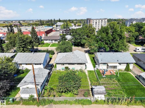 Expansive backyard featuring a manicured lawn, established garden beds, and a storage shed - 5207 48 Avenue, Leduc, AB - Outdoor With View