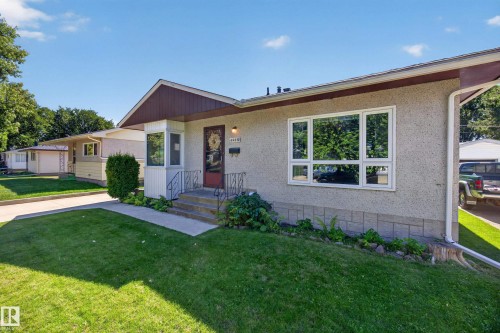 Stucco exterior with a peaked roofline, bay window, and a prominent front door with a transom window - 5207 48 Avenue, Leduc, AB - Outdoor
