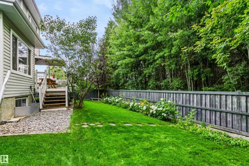 Expansive backyard featuring a manicured lawn, established landscaping, and a wooden privacy fence - 1720 Robertson Place Sw, Edmonton, AB - Outdoor