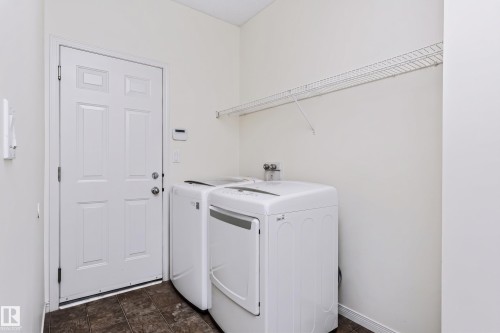 Utility room with a white paneled door, wire shelving, and durable flooring - 1720 Robertson Place Sw, Edmonton, AB - Indoor Photo Showing Laundry Room