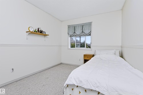 Wall-to-wall carpeting with light neutral walls, featuring a single window - 1720 Robertson Place Sw, Edmonton, AB - Indoor Photo Showing Bedroom
