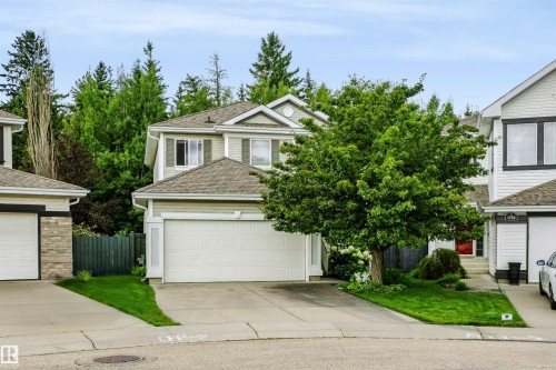 Two-story residence with light-toned siding, attached garage, and a gabled roofline - 1720 Robertson Place Sw, Edmonton, AB - Outdoor