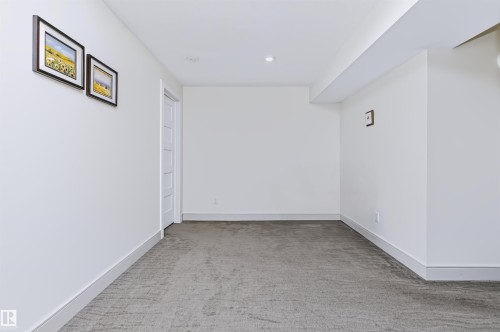 Recessed lighting, white walls, gray carpeting, white trim, and a white interior door with horizontal panels - 1720 Robertson Place Sw, Edmonton, AB - Indoor Photo Showing Other Room