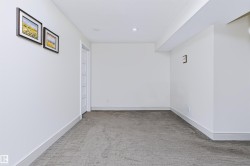 Recessed lighting, white walls, gray carpeting, white trim, and a white interior door with horizontal panels - 
