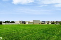 Expansive green space with distant multi-story structures - 