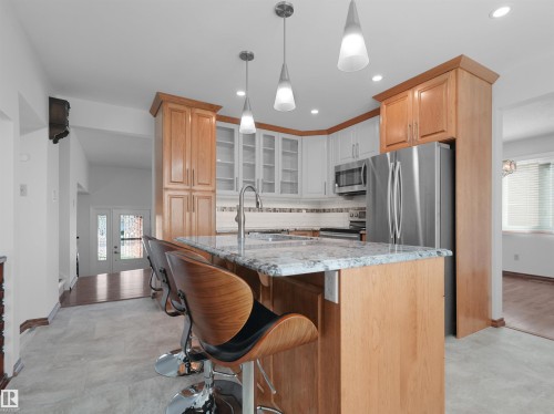 Kitchen featuring an island with stone countertop, stainless steel appliances, recessed lighting, and pendant lighting - 7357 18 Avenue Nw, Edmonton, AB - Indoor Photo Showing Kitchen With Upgraded Kitchen