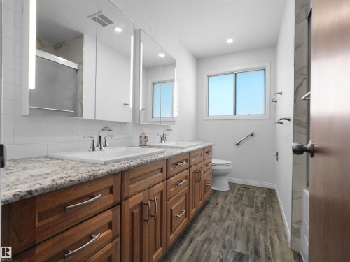 Dual vanity with granite-style countertops and undermount sinks - 7357 18 Avenue Nw, Edmonton, AB - Indoor Photo Showing Bathroom