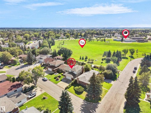 Aerial view of a residential neighborhood featuring detached homes with attached garages, mature landscaping, and paved streets - 7357 18 Avenue Nw, Edmonton, AB - Outdoor With View