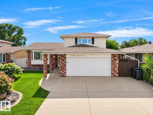Two-story brick exterior with white garage doors, manicured front lawn, mature landscaping, concrete driveway, and second-story dormer windows - 7357 18 Avenue Nw, Edmonton, AB - Outdoor
