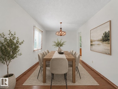 Warm wood-finish flooring complements the neutral wall tones - 7357 18 Avenue Nw, Edmonton, AB - Indoor Photo Showing Dining Room