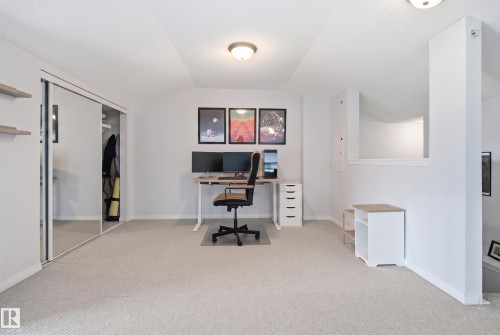 Recessed ceiling, neutral carpeting, mirrored sliding closet doors, and overhead lighting - #2415 9357 Simpson Dr Nw, Edmonton, AB - Indoor Photo Showing Other Room