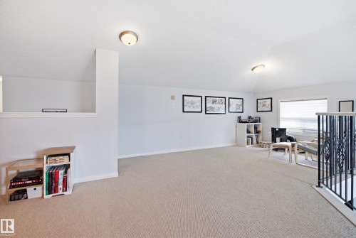 Expansive carpeted area with neutral walls, recessed ceiling lights, and multiple windows with blinds - #2415 9357 Simpson Dr Nw, Edmonton, AB - Indoor Photo Showing Other Room