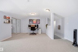 Carpeted room with a half-wall partition and recessed lighting - 