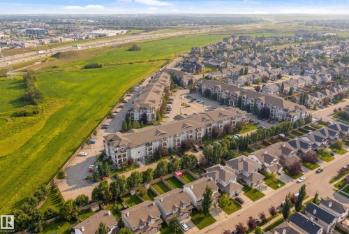 Expansive residential development featuring multi-story buildings, single-family homes, and surrounding green spaces - #2415 9357 Simpson Dr Nw, Edmonton, AB - Outdoor With View