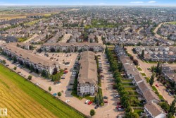 Expansive residential area featuring a mix of multi-story buildings and single-family homes, ample surface parking, and mature trees lining streets and property boundaries - 