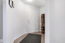 Entryway featuring a white paneled door, light wood-finish flooring, and neutral wall tones - 