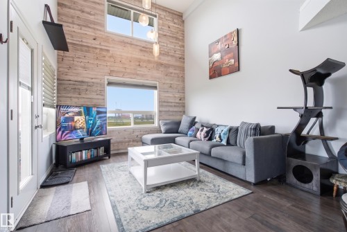 Vaulted ceiling featuring a wood-paneled accent wall and large windows - #2415 9357 Simpson Dr Nw, Edmonton, AB - Indoor