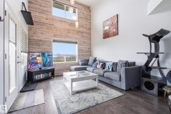 Vaulted ceiling featuring a wood-paneled accent wall and large windows - 