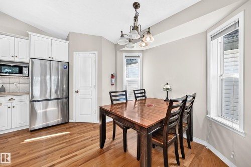 Wood-finish flooring with white cabinetry, stainless steel refrigerator, and recessed lighting - 4210 37 Avenue Nw, Edmonton, AB - Indoor