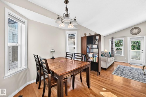 Hardwood flooring throughout, vaulted ceiling, bay windows, and a glass-paneled exterior door - 4210 37 Avenue Nw, Edmonton, AB - Indoor