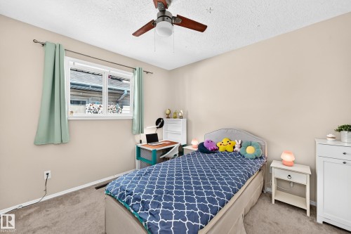 Neutral-toned walls, a window with a white frame, and a ceiling fan with light fixture - 4210 37 Avenue Nw, Edmonton, AB - Indoor Photo Showing Bedroom