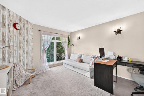 Light-colored carpeting, window with multiple panes, two wall sconces, wood-finish accent wall, built-in desk - 4210 37 Avenue Nw, Edmonton, AB - Indoor
