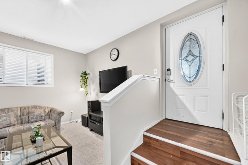 Entryway featuring a decorative oval glass insert door and wood-finish stairs - 4210 37 Avenue Nw, Edmonton, AB - Indoor