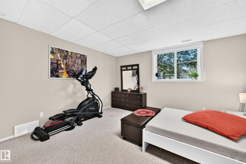 Wall-to-wall carpeting with neutral wall tones and a drop ceiling - 4210 37 Avenue Nw, Edmonton, AB - Indoor