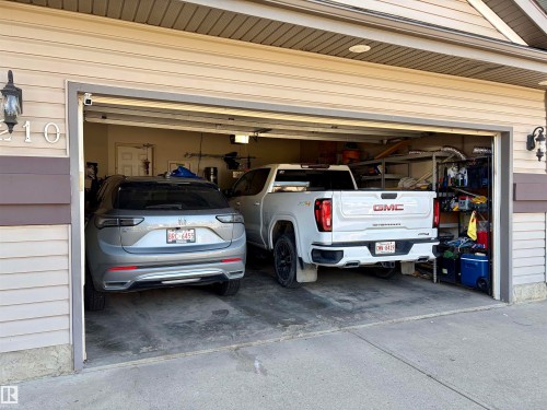 Two-car garage with concrete flooring and a white paneled door - 4210 37 Avenue Nw, Edmonton, AB - Indoor Photo Showing Garage