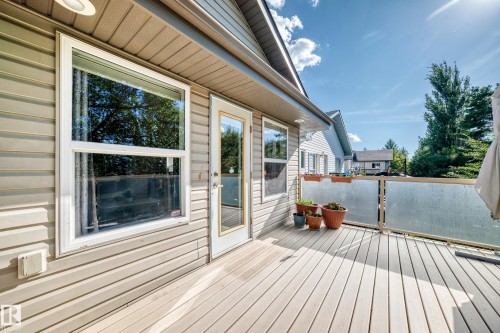 Expansive outdoor deck featuring wood-finish flooring, frosted glass panel railing, and direct access to the interior - 4210 37 Avenue Nw, Edmonton, AB - Outdoor With Deck Patio Veranda With Exterior