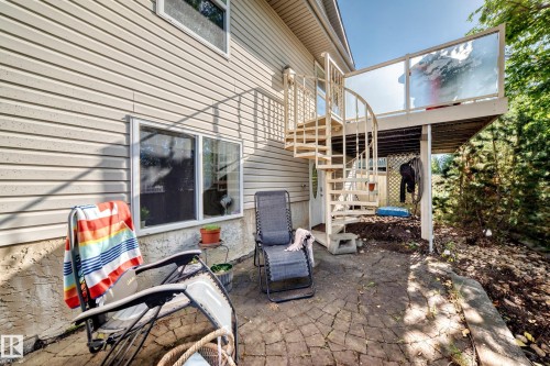 Exterior featuring horizontal siding, a spiral staircase, and a deck with glass panel railing - 4210 37 Avenue Nw, Edmonton, AB - Outdoor With Deck Patio Veranda With Exterior