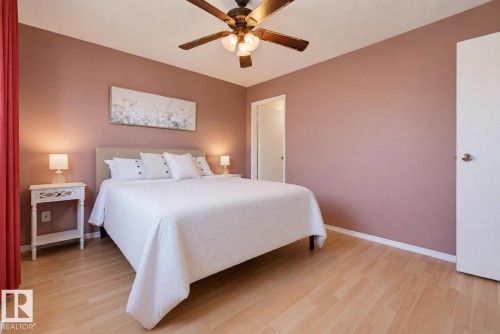 Wood-finish flooring with a ceiling fan light fixture - 6768 39 Avenue Nw, Edmonton, AB - Indoor Photo Showing Bedroom