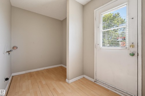 Wood-finish flooring with light-toned walls - 6768 39 Avenue Nw, Edmonton, AB - Indoor Photo Showing Other Room