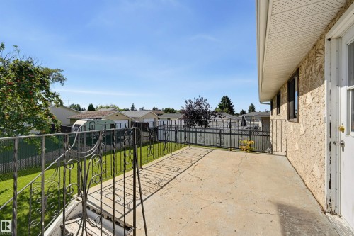 Spacious concrete patio with decorative wrought iron railing and stucco exterior - 6768 39 Avenue Nw, Edmonton, AB - Outdoor